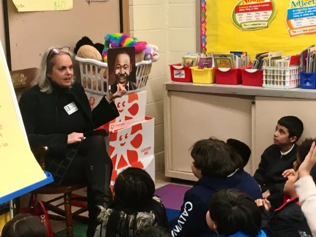 A mentor reading with students during a Saturday literacy session