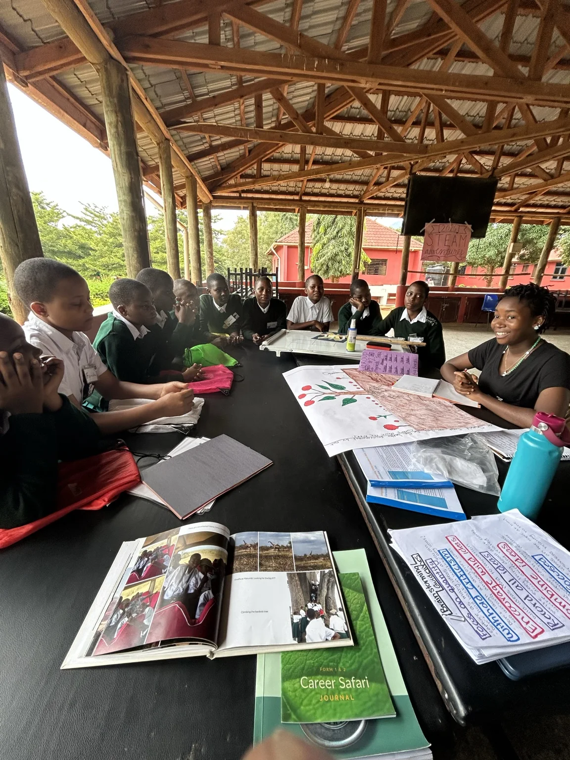 Students and a facilitator gathered around books and literacy materials during an African school workshop