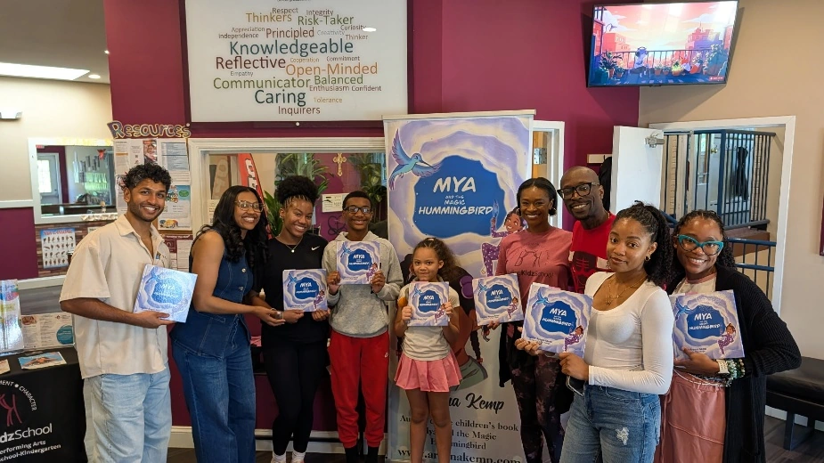 Community members and young readers holding copies of Mya and the Magic Hummingbird
